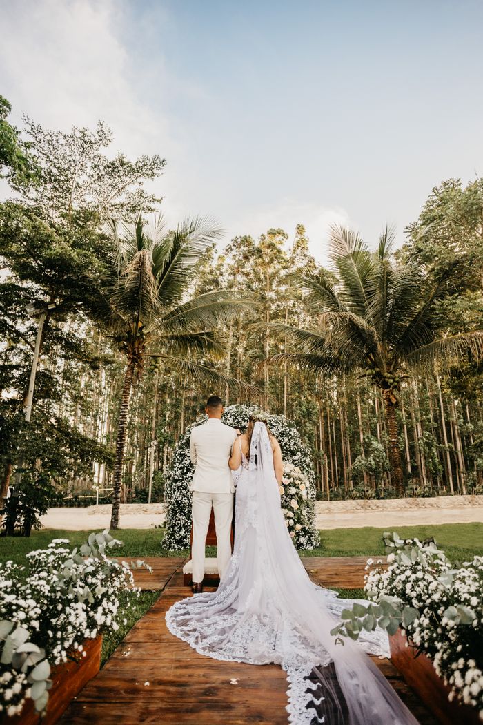 Mastering the First Impression: Your intriguing post title goes here Back view anonymous newlywed couple wearing classy white outfits standing near arbor in lush park during solemn wedding ceremony